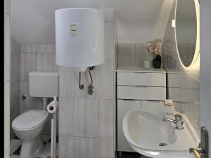 a white bathroom with a toilet and a sink at Apartmani Zinda in Sukošan +47 photos