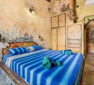 a bedroom with a large bed with blue sheets at Casa Gaudi - House & Rooms in Teulada