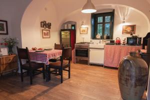 a kitchen with a table and chairs and a kitchen with a sink at Villa Rustica Vendégház Sümeg in Sümeg