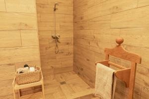 a bathroom with a shower with a wooden floor at Villa Rustica Vendégház Sümeg in Sümeg +20 photos