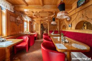 a restaurant with red chairs and wooden ceilings at Wisła Mountain SPA in Wisła