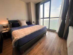 a bedroom with a bed and a large window at Breath Taking View, Amazing Sea View Room in Pattaya South
