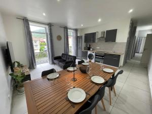 a dining room and kitchen with a wooden table and chairs at Entre Rivière et Sommets in Seix