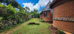 a brick house with a yard next to a building at The Fort Valley BnB , Karatu in Karatu