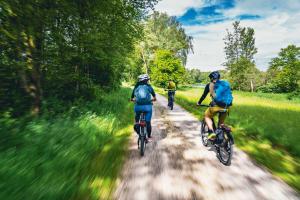 three people riding bikes down a dirt road at Hotel Sonnenhof in Bad Birnbach