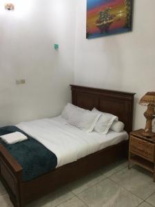 a bed with white sheets and pillows in a room at Meublé de toursime L'Escale in Yaoundé