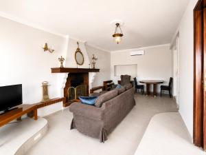 a living room with a couch and a fireplace at Villa LaThea in Akti Salonikiou