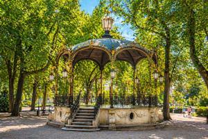 a gazebo with stairs in a park with trees at Sous le Charme de Charles Sauna & Jacuzzi Nancy in Nancy