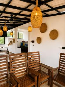 a dining room with two wooden benches and lights at AZORA Boutique Studios in Ahangama