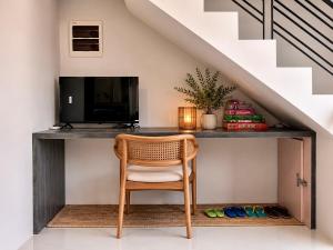 a desk under the stairs with a chair and a television at Idesia Lipa Custodio Suites in Lipa