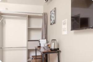 a kitchen with a refrigerator and a table with a microwave at Chambre Attrape rêves in Sainte-Geneviève-des-Bois