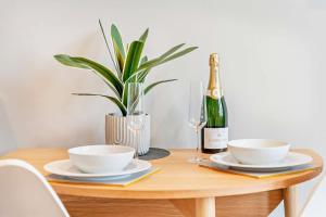 a table with a bottle of champagne and a plant at Beach Walk Southbourne SOBO Beach Sleeps 4 in Southbourne