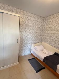 a bedroom with a bed and a wall with triangles at Loft 102 Farol de Santa Marta in Laguna