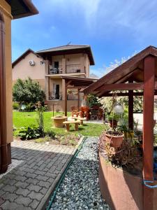 a backyard with a house and a patio with a table at Adrienn Apartman in Sárvár