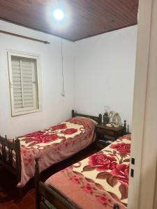 a bedroom with two beds and a window and a table at Marisol in Apóstoles
