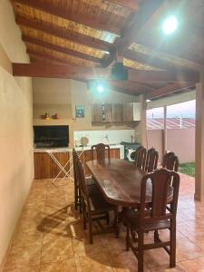 a dining room with a table and chairs and a kitchen at Marisol in Apóstoles