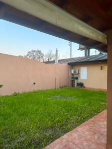 a yard with green grass next to a house at Marisol in Apóstoles
