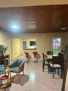 a living room with tables and chairs and a kitchen at Marisol in Apóstoles