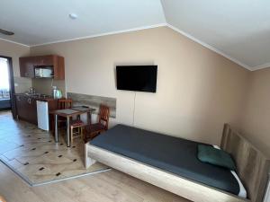 a bedroom with a bed and a table and a tv at Adrienn Apartman in Sárvár