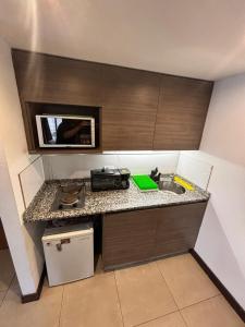 a small kitchen with a sink and a microwave at monoambiente castelar in Castelar
