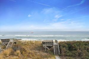two beach chairs sitting on top of a beach at Dream Catcher - Nags Head MP 12, Oceanfront, Elevator, Pool, Hot Tub, Pets OK, YR Flex in Nags Head