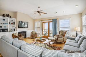 a living room with a couch and a tv at Dream Catcher - Nags Head MP 12, Oceanfront, Elevator, Pool, Hot Tub, Pets OK, YR Flex in Nags Head