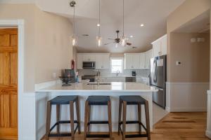 a kitchen with a large island with two bar stools at Dream Catcher - Nags Head MP 12, Oceanfront, Elevator, Pool, Hot Tub, Pets OK, YR Flex in Nags Head