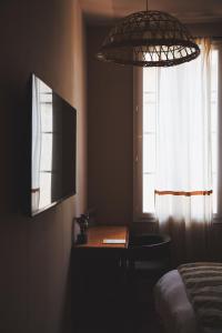 a bedroom with a table and a television and a window at LE CLOS DES ARÔMES in Cassis