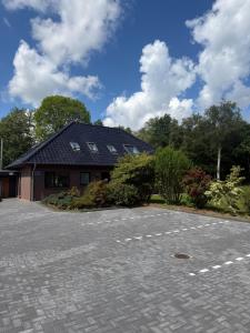 a house with a driveway in front of it at Ferienwohnung Moorblick in Osten