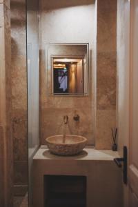 a bathroom with a stone sink and a mirror at LE CLOS DES ARÔMES in Cassis +32 photos