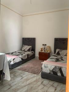 a bedroom with two beds and a dresser at Belyounech in Belyounech 