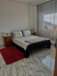 a bedroom with a bed with a window and a red rug at Belyounech in Belyounech  +22 photos