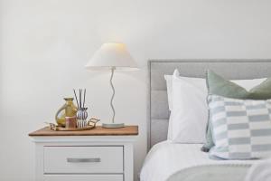 a bed with a night stand with a lamp on it at The Tobias in Perth