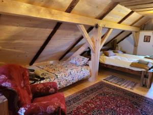 a bedroom with a bed and a chair in a attic at Oddih v Srčni hiški in Dvor