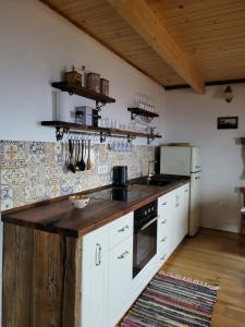 a kitchen with white cabinets and a wooden counter top at Oddih v Srčni hiški in Dvor