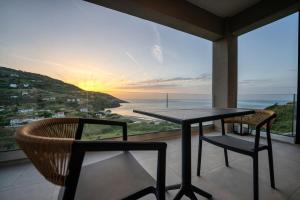 a table and chairs on a balcony with a view of the ocean at Akissare in Kámpos