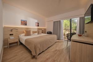a hotel room with a bed and a balcony at Hotel Playa Mondrago in Portopetro