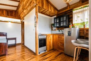 a kitchen with wooden floors and a refrigerator at Cabañas Bella Vista in Hojancha +25 photos