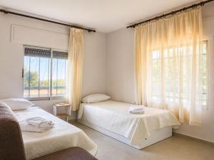 a bedroom with two beds and a window at Villa LaThea in Akti Salonikiou