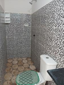 a bathroom with a toilet and a tiled shower at Pousada Praiamar in Beberibe +37 photos
