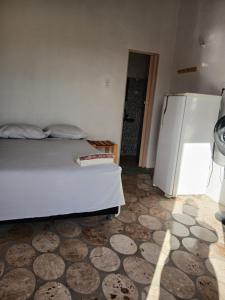 a bedroom with a bed and a refrigerator at Pousada Praiamar in Beberibe
