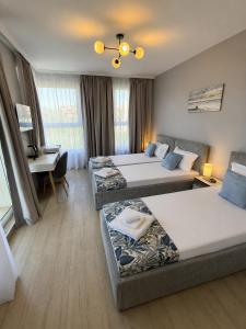 a hotel room with two beds and a desk at Къща Грийн Хаус in Chernomorets