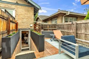 a backyard patio with a wooden fence and a blue chair at Charming Washington Park Getaway in Denver