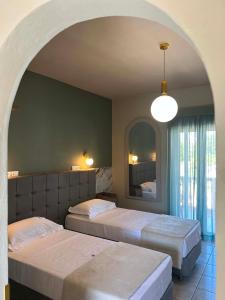 zwei Betten in einem Schlafzimmer mit einem Torbogen in der Unterkunft Jolly Pad Deluxe Studio - 5 min walk to Tsilivi Beach in Planos + 61 Fotos