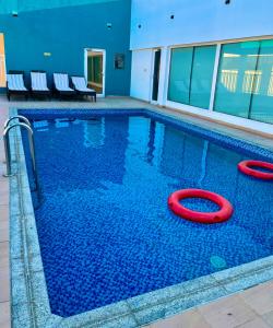 a pool with two red rings in the water at Saffron Hotel and Lounges in Muscat +17 photos