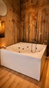 a white bath tub in a room with trees on the wall at Vittorio Veneto Dimore in Bari