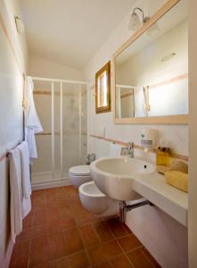 a bathroom with two sinks and a shower at Hotel Corallo in Pomonte +37 photos