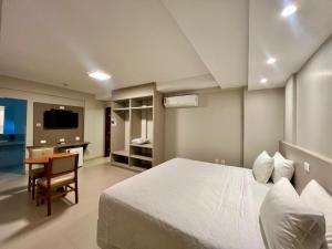 ein Schlafzimmer mit Bett, Schreibtisch und Fernseher in der Unterkunft Novares Hotel in Goiânia
