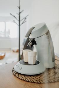 a coffee maker with two cups on a table at Gemütliche Ferienwohnung in Riedlingen
