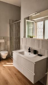a bathroom with a large white sink and a toilet at Vittorio Veneto Dimore in Bari